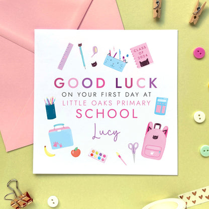 A personalised first day at school card for girl, featuring different school related objects in a pink theme. It can be personalised with the school and the child's name. It's suitable for primary school, secondary school, infant school and nursery, for relations such as daughter, granddaughter, niece, cousin, sister and little girl.