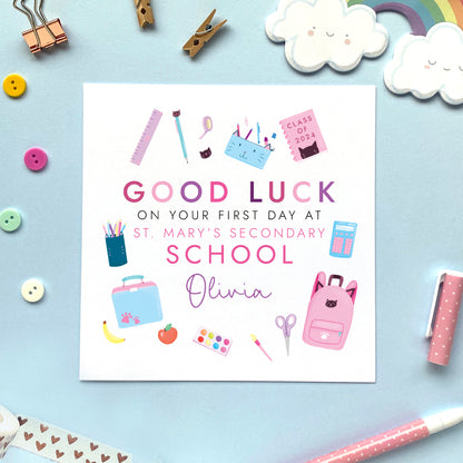 A personalised first day at school card for girl, featuring different school related objects in a pink theme. It can be personalised with the school and the child's name. It's suitable for primary school, secondary school, infant school and nursery, for relations such as daughter, granddaughter, niece, cousin, sister and little girl.