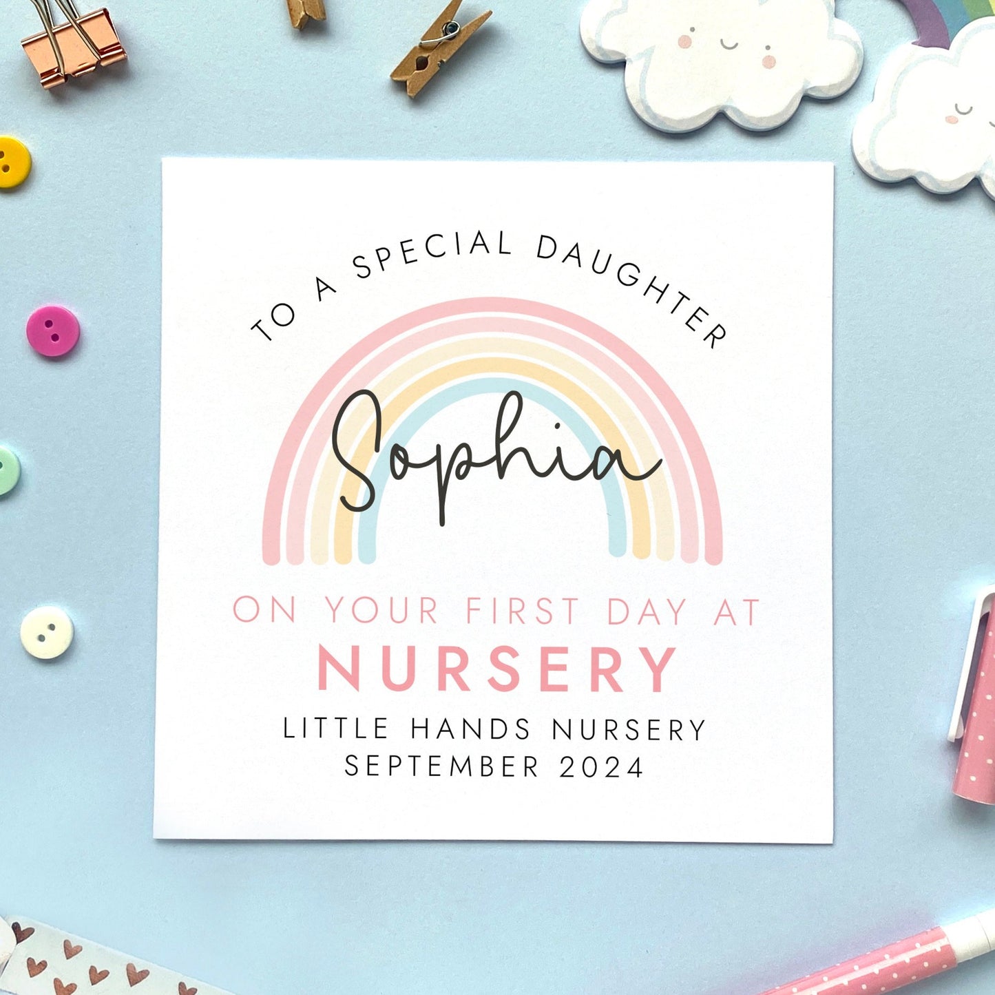 A personalised first day at nursery card for girl, featuring a pink rainbow. It can be personalised with a child's name, school and date. It is also suitable for 1st day at primary school, secondary school, nursery and infant school. The relation can be changed to daughter, granddaughter, niece, cousin, sister or goddaughter.