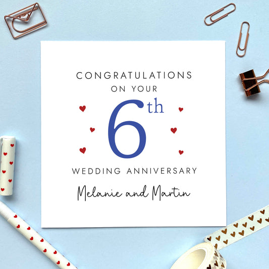 A personalised 6th wedding anniversary card for couple. It features '6th' in navy blue with red hearts, the colour scheme matches the theme of sugar. The text reads 'Congratulations on your 6th wedding anniversary'. This card can be personalised with two names, and is suitable for special friends and family relations such as Daughter and Son-in-Law and Son and Daughter-in-Law. It is also suitable for gay and lesbian couples.