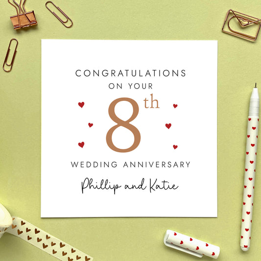 A personalised 8th wedding anniversary card for couple. It features '8th' in bronze brown with red hearts, the colour scheme matches the theme of bronze. The text reads 'Congratulations on your 8th wedding anniversary'. This card can be personalised with two names, and is suitable for special friends and family relations such as Daughter and Son-in-Law and Son and Daughter-in-Law. It is also suitable for gay and lesbian couples.