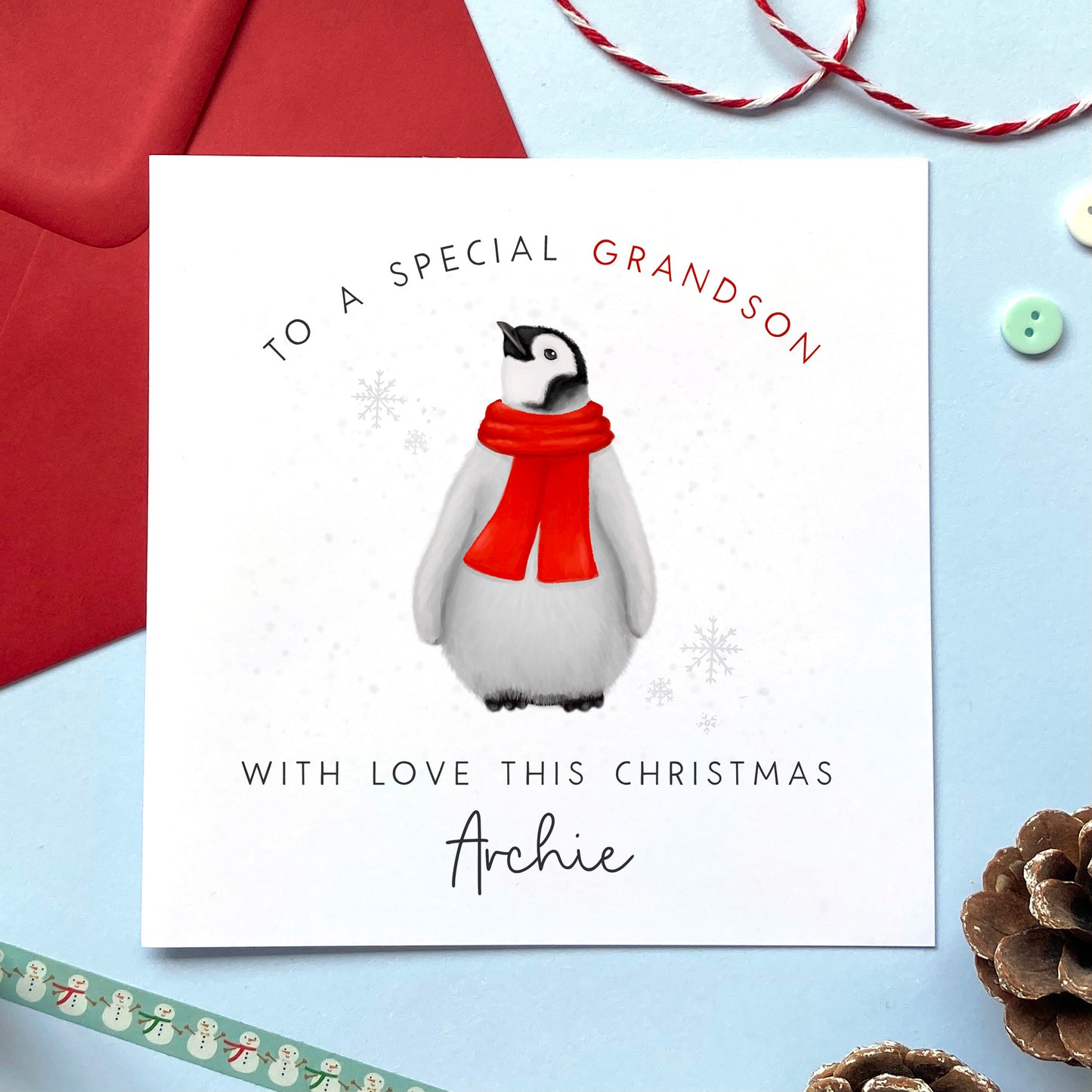 A personalised Christmas card for children featuring a baby penguin in a red scarf. It can be personalised with any relation for both boy and girl, including Son, Grandson, Nephew, Daughter, Granddaughter and Niece. A name can be added under 'with love this Christmas'.