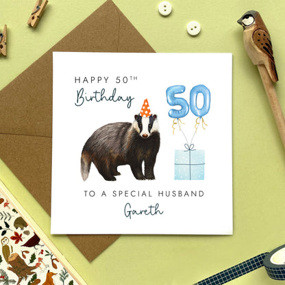 A personalised birthday card for him featuring a british badger. The card in the photo is for a 50th birthday card for husband.