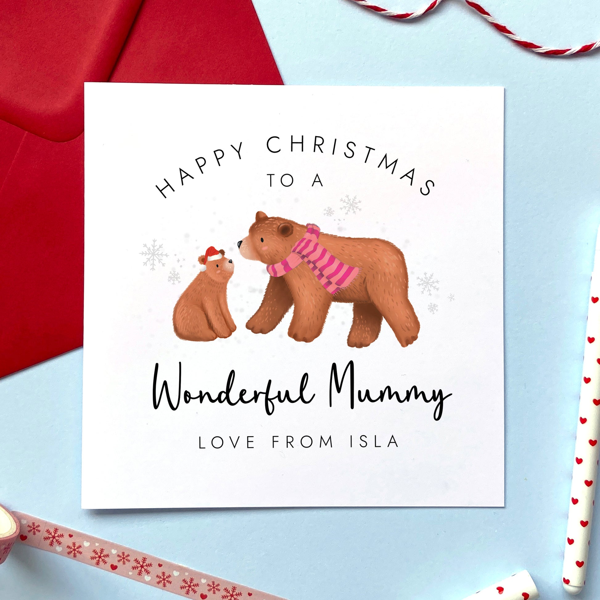 A personalised Christmas card for Mummy featuring a big brown bear wearing a stripy pink scarf, and a baby bear wearing a santa hat. It can be personalised with the child's name, and is suitable for any mother from her son or daughter.