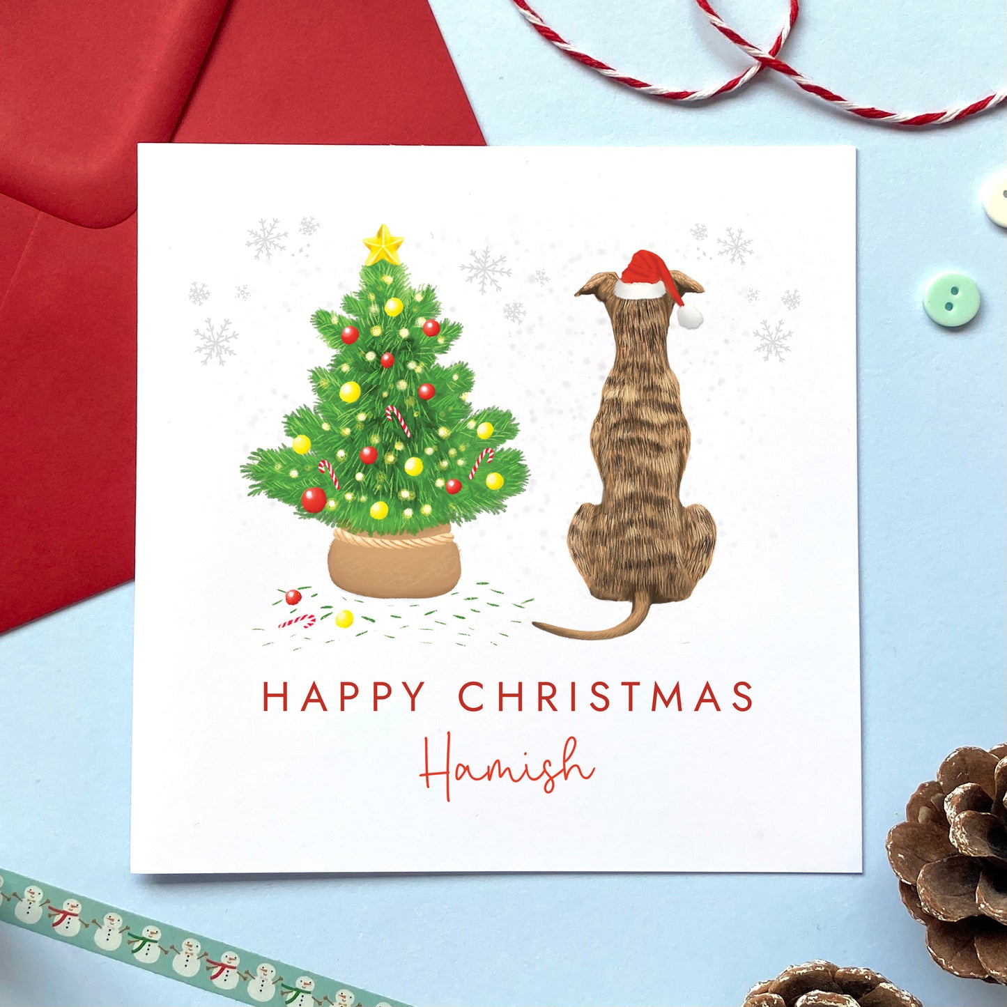 A personalised dog Christmas card featuring a brindle brown and black whippet or greyhound.