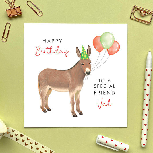 A personalised birthday card for her or him featuring a donkey with birthday balloons. It can be personalised with a name, relation and any age. The card in the photo is a birthday card for Friend.