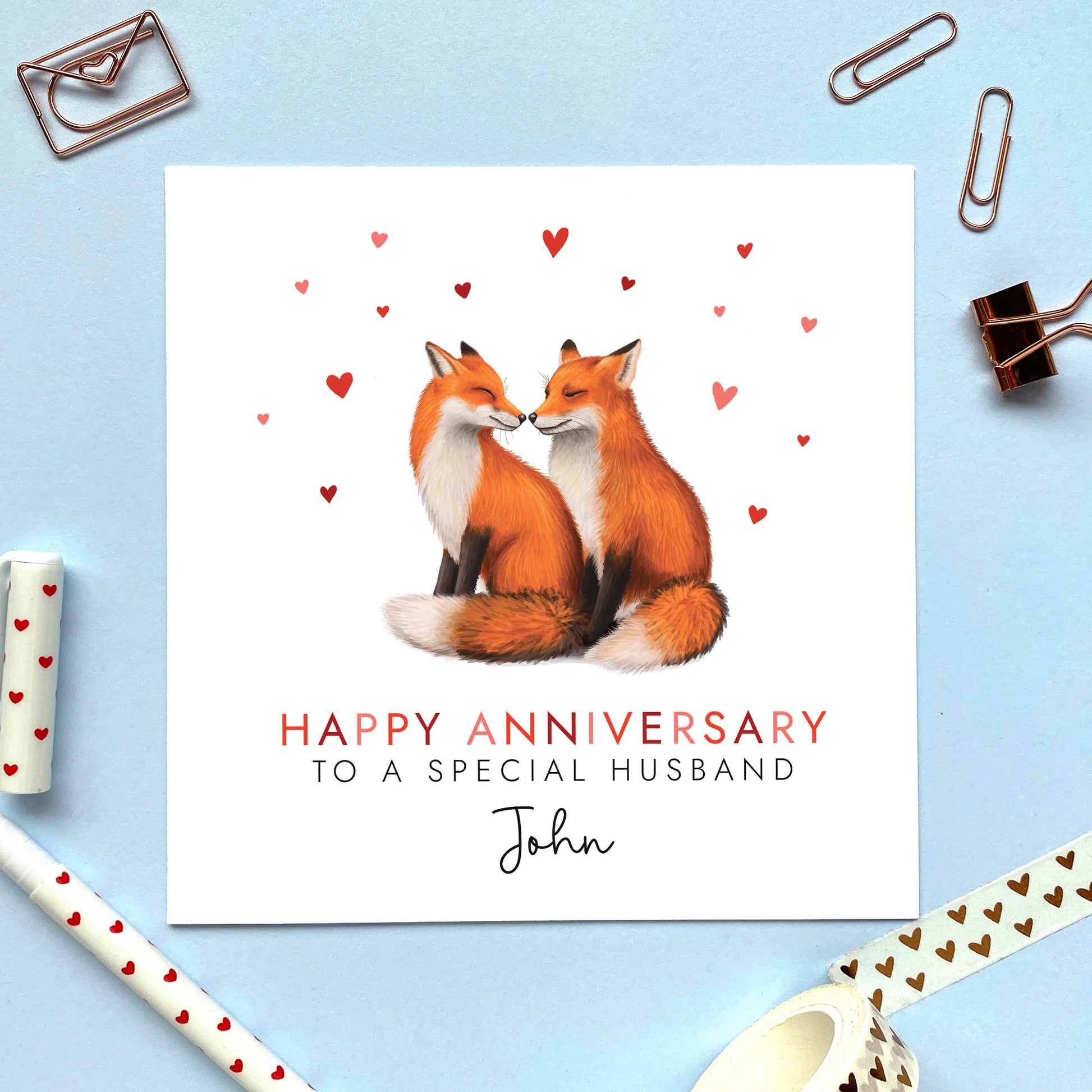 A personalised anniversary card featuring two foxes surrounded by hearts. It is suitable for any relation such as husband, wife, girlfriend, boyfriend, fiance, fiancee and partner. It can be personalised with any name.