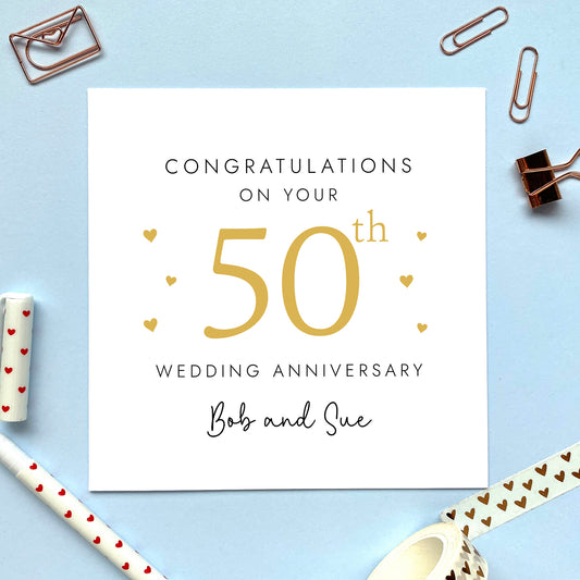 A personalised 50th wedding anniversary card for couple. It features '50th' in gold with red hearts, the colour scheme matches the theme of gold or golden. The text reads 'Congratulations on your 50th wedding anniversary'. This card can be personalised with two names, and is suitable for special friends and family relations such as parents, grandparents, Mum and Dad, Brother and Sister in Law, Daughter and Son-in-Law and Son and Daughter-in-Law. It is also suitable for gay and lesbian couples.