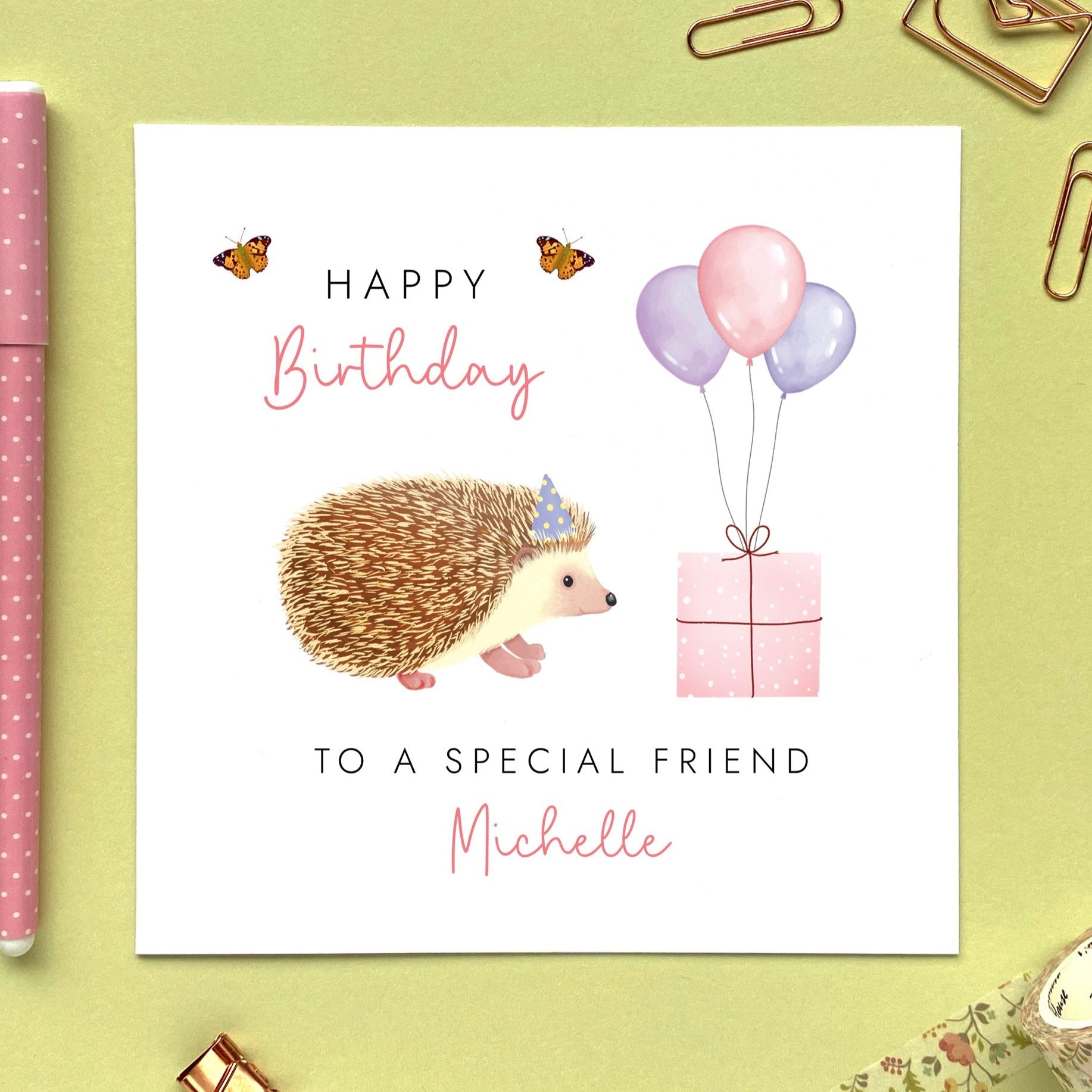 A personalised hedgehog birthday card for Her. It is pink and purple themed, and can be personalised with a name and any age. The card in the photo is a birthday card for friend.