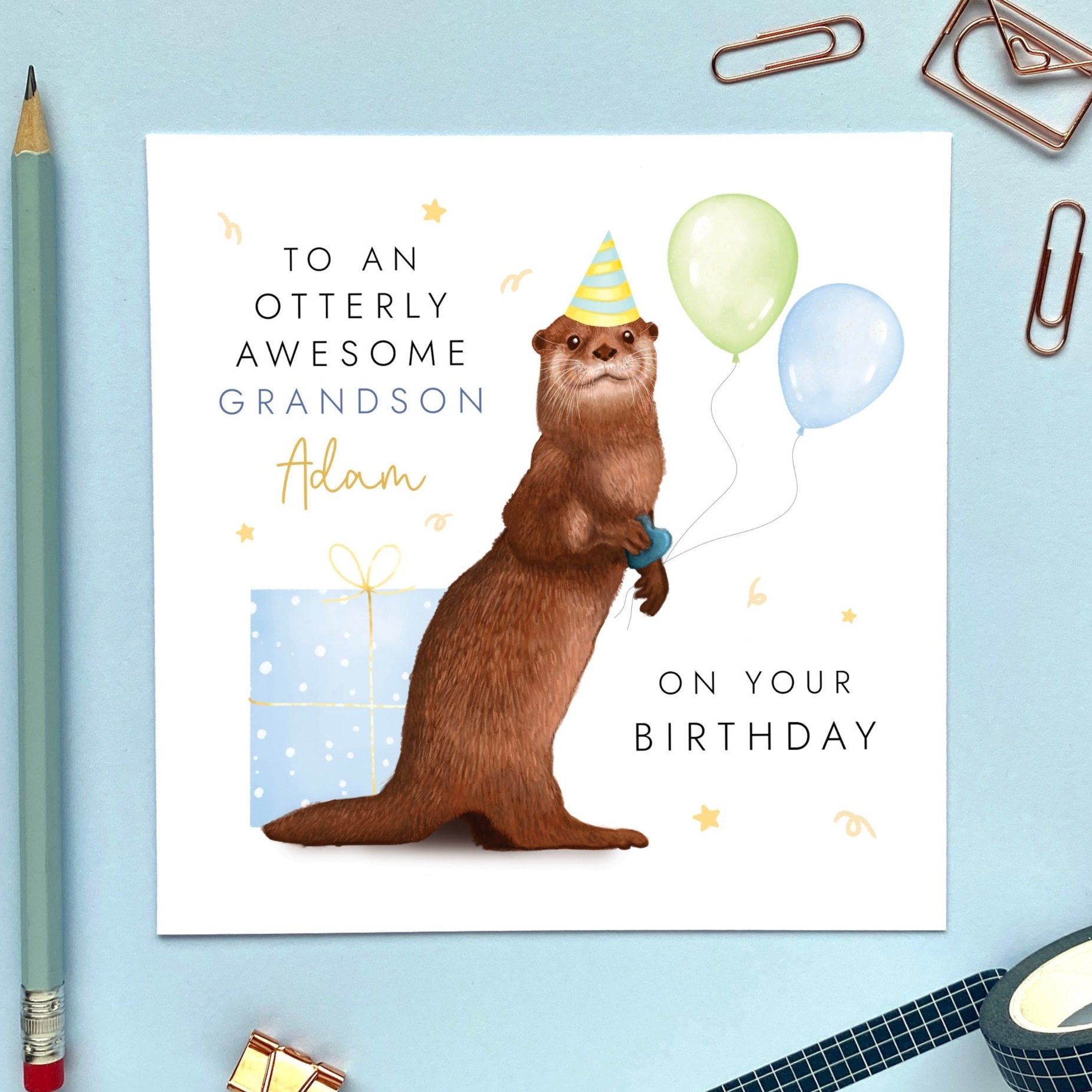 A personalised birthday card featuring a brown otter holding green and blue balloons, with a blue present. It's suitable for any age, including 1st, 2nd, 3rd, 4th, 5th, 6th and 10th. It's a good card for children, especially boys. It can be personalised with a relation, such as Son, Grandson or Nephew, and a name can also be added.