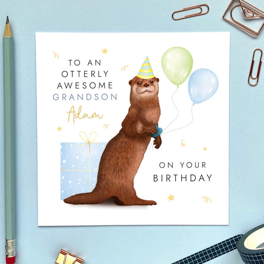 A personalised birthday card featuring a brown otter holding green and blue balloons, with a blue present. It's suitable for any age, including 1st, 2nd, 3rd, 4th, 5th, 6th and 10th. It's a good card for children, especially boys. It can be personalised with a relation, such as Son, Grandson or Nephew, and a name can also be added.