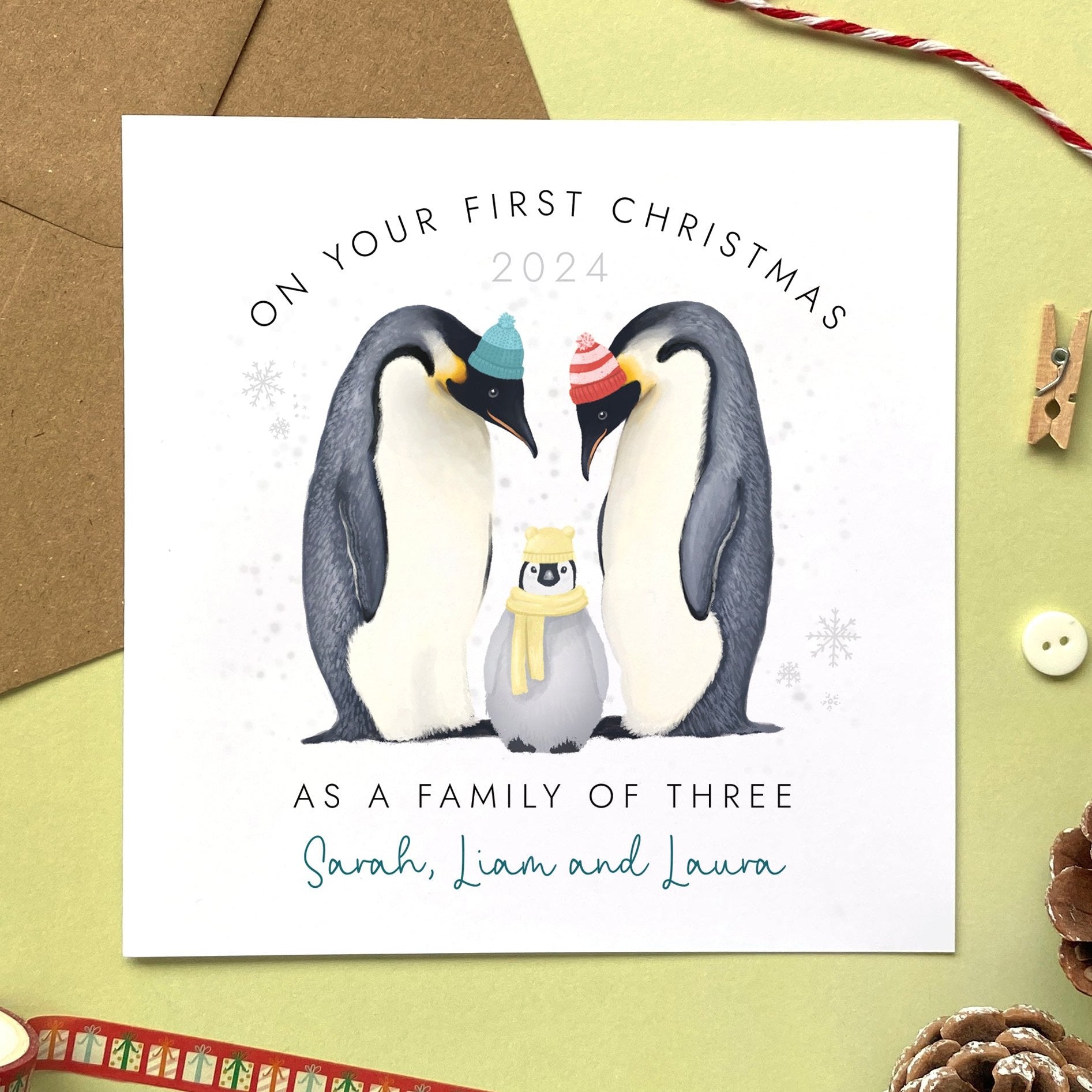 A Personalised Christmas Card for 'on your first Christmas as a Family of Three'. It features two adult penguins to represent a couple and a baby penguin to represent a new baby boy or girl.