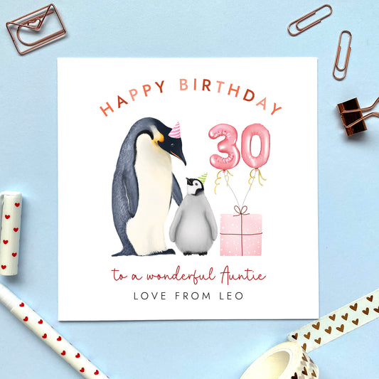 A personalised penguins 30th birthday card for Auntie, featuring an adult penguin standing next to a baby penguin, a pink present with pink 30 balloons. It can be personalised with the child's name from a niece or nephew.