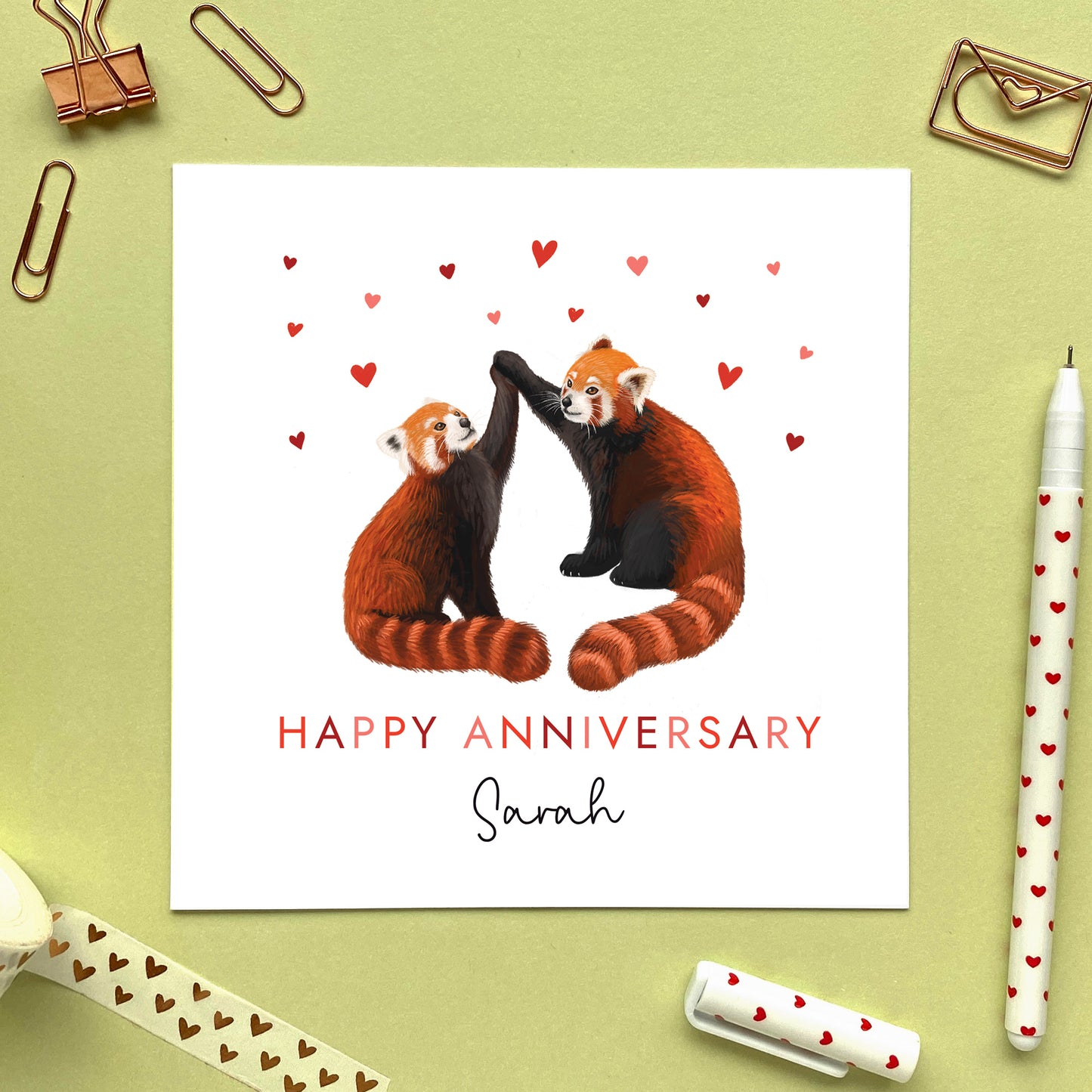 A personalised anniversary card for partner featuring a pair of red pandas with hearts. It can be personalised with a name and is suitable for both him and her. Ideal for husband, wife, fiancé, fiancée, boyfriend and girlfriend, for any anniversary such as 1st wedding anniversary.