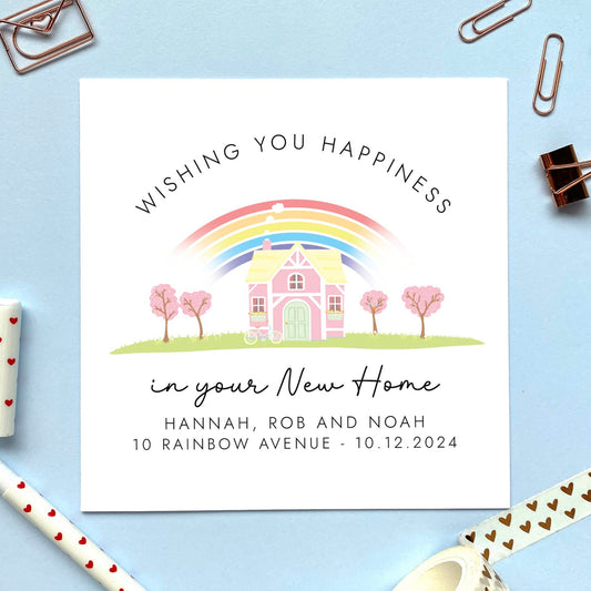 A personalised new home card featuring a rainbow and pink house. It says 'wishing you happiness in your new home'.