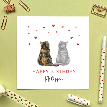 A personalised cats birthday card for partner where you can choose the two cats on the card. You can choose from a range of different cat breeds and colours, including ginger, black, tabby, ragdoll, grey and bengal cats. It can be personalised with any name. Ideal for both him and her, fiancee, fiance, husband, wife, boyfriend or girlfriend. The photo shows a calico cat and a grey cat.